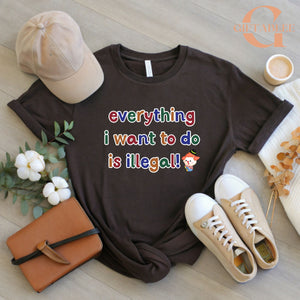 a black t-shirt with a colorful text message, a beige baseball cap, a brown leather book, a pair of white sneakers, and some flowers and a cup.