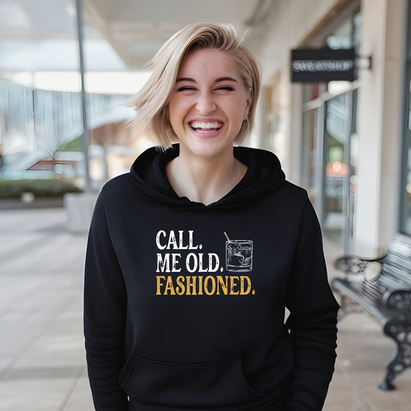 A smiling woman wearing a black hoodie with text printed on it.