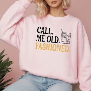 A woman wearing a pink sweatshirt with the text "CALL. ME OLD. FASHIONED." printed on it.