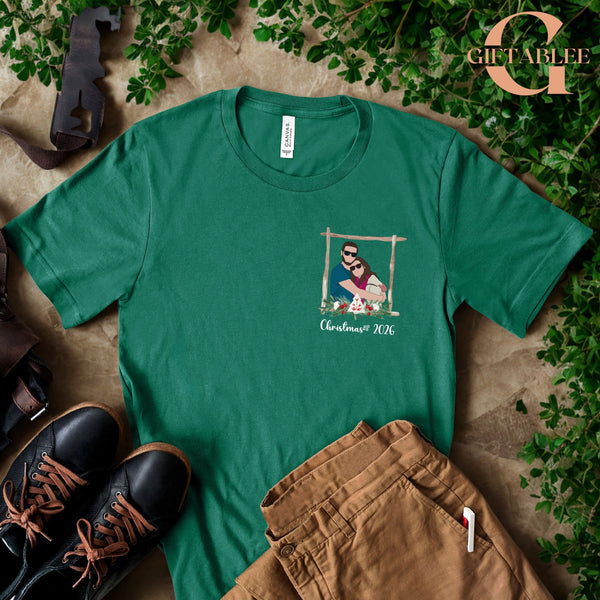a green t-shirt with a graphic design, a pair of brown pants, and a pair of black shoes, all laid out on a surface with some greenery.