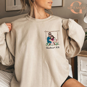 A woman wearing a beige sweater with a graphic design of a couple embracing, along with the text "Christmas 2016" printed on it.