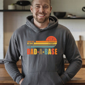 A man wearing a gray hoodie with a graphic design on it, smiling and posing for the camera.