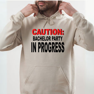 A man wearing a beige hoodie with a bold warning text printed on it.