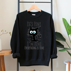 A black sweatshirt with a graphic design featuring a cat with a surprised expression and text that reads "It's fine, I'm fine, everything is fine".