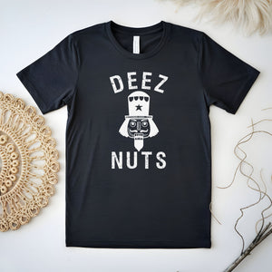 A black t-shirt with the text "DEEZ NUTS" printed on it, along with a nutcracker or nutcracker-like figure.