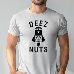 A man wearing an athletic heather t-shirt with a graphic design featuring a nutcracker or nutcracker-like figure and the text "DEEZ NUTS".