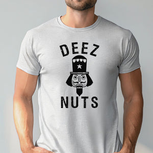 A man wearing an athletic heather t-shirt with a graphic design featuring a nutcracker or nutcracker-like figure and the text "DEEZ NUTS".