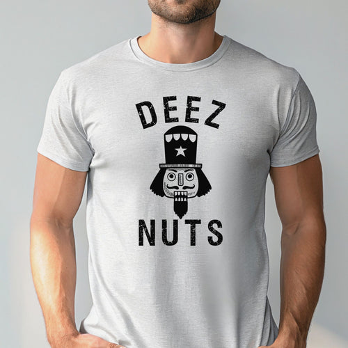 A man wearing an athletic heather t-shirt with a graphic design featuring a nutcracker or nutcracker-like figure and the text "DEEZ NUTS".
