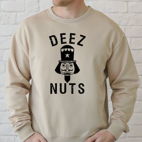 A man wearing a sand sweater with a graphic design that says "DEEZ NUTS" and features a nutcracker or nutcracker-like character.