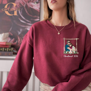 A woman wearing a burgundy sweater with a Christmas-themed graphic on the front.