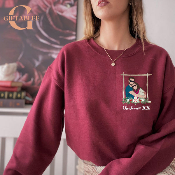 A woman wearing a burgundy sweater with a Christmas-themed graphic on the front.