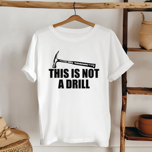 A white t-shirt with a humorous text printed on it, hanging on a wooden hanger.