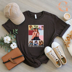 a black t-shirt with a collage of photos, a beige baseball cap, a brown leather book, a pair of white sneakers, and some flowers.