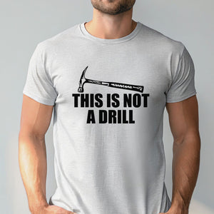 A man wearing a gray t-shirt with a humorous text printed on it.