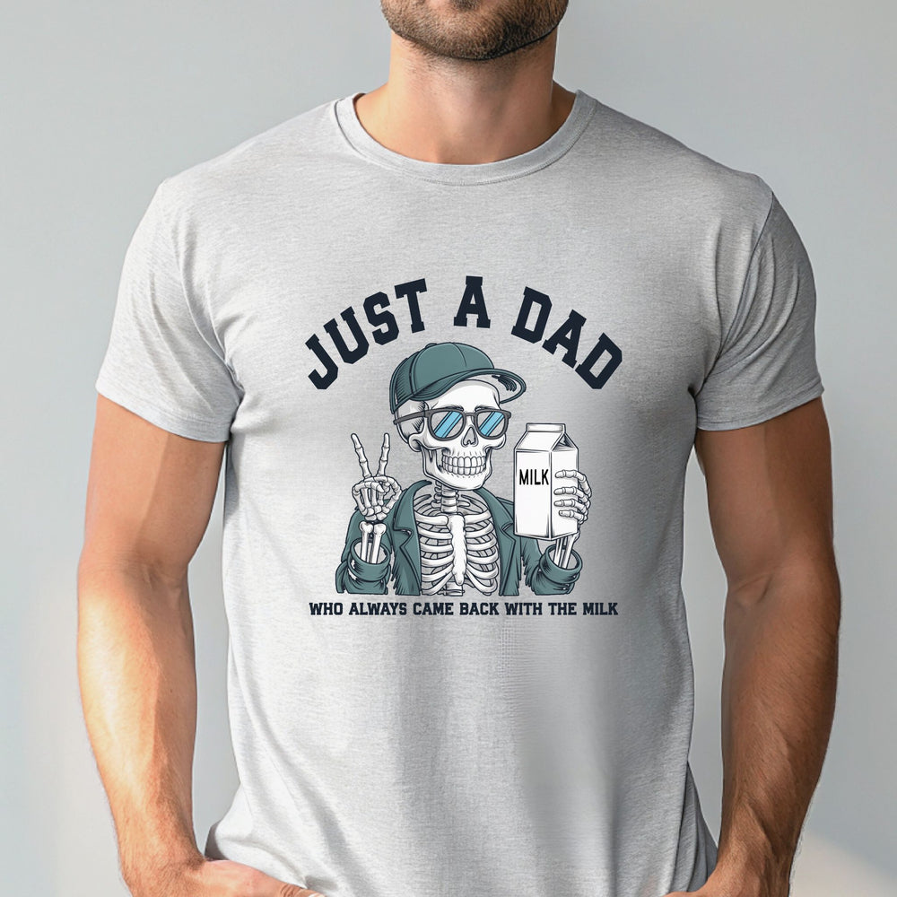 A man wearing a gray t-shirt with a graphic design depicting a skeleton wearing sunglasses and holding a carton of milk, with the text "Just a Dad" above the image.