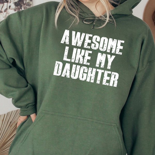 A person wearing a green hoodie with the text "AWESOME LIKE MY DAUGHTER" printed on it.