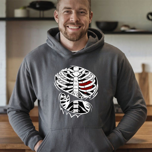 A man wearing a gray hoodie with a graphic design of a skeleton on it, smiling at the camera.