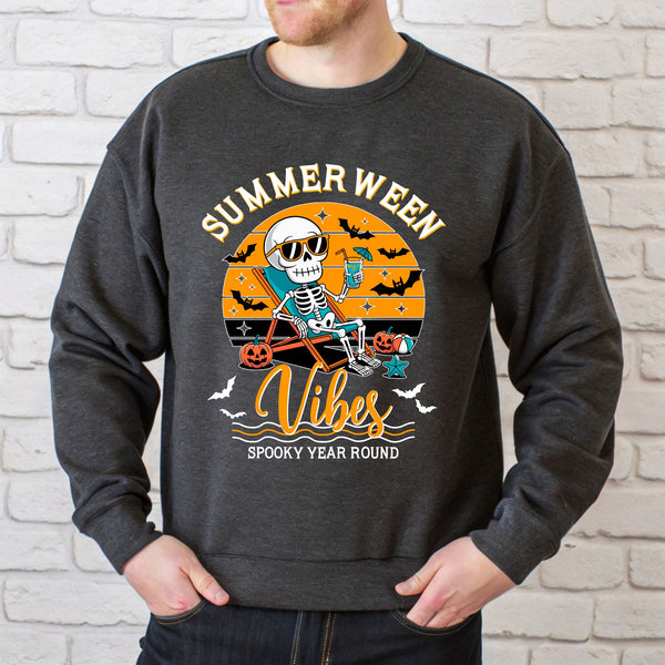 A man wearing a gray sweatshirt with a graphic design featuring a skeleton holding a drink and the text "Summer Ween Vibes Spooky Year Round".