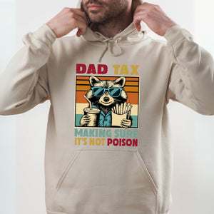 A man wearing a white hoodie with a graphic design of a raccoon wearing sunglasses and holding a drink.