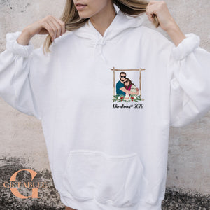 A woman wearing a white hoodie with a graphic design on the front.