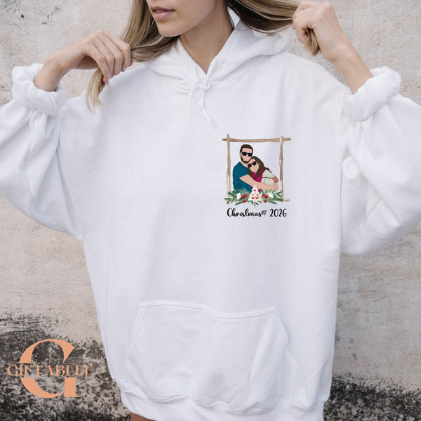 A woman wearing a white hoodie with a graphic design on the front.