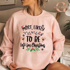 A woman wearing a pink sweatshirt with a humorous Christmas-themed text printed on it.