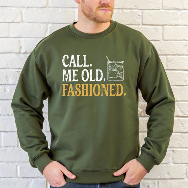 A man wearing a green sweatshirt with the text "Call me old, I'm fashionable" printed on it.