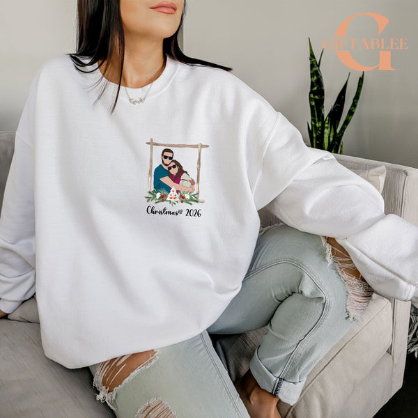 A woman wearing a white sweater with a graphic design of a couple embracing, sitting on a couch.
