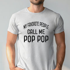 A man wearing a gray t-shirt with the text "MY FAVORITE PEOPLE CALL ME POP POP" printed on it.