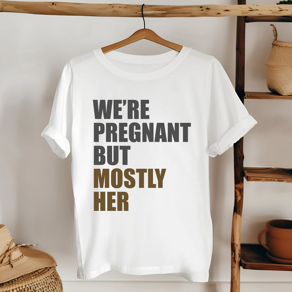 A white t-shirt with text printed on it, hanging on a wooden hanger.