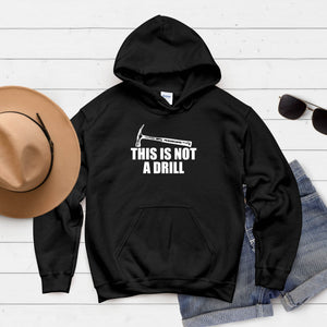 A black hoodie with a humorous text printed on it, along with a pair of sunglasses and a hat, all laid out on a white background.