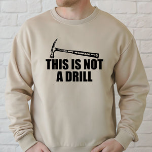 A man wearing a beige sweater with a humorous text printed on it.