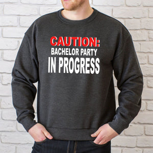 A man wearing a grey sweatshirt with a humorous text printed on it.