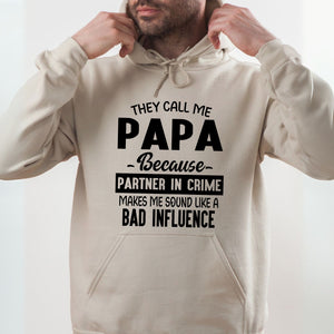 A man wearing a beige hoodie with a humorous text printed on it.