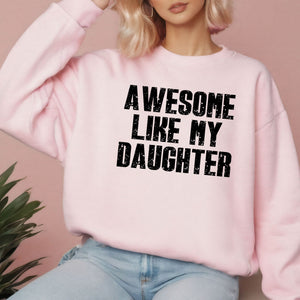 A woman wearing a pink sweatshirt with the text "AWESOME LIKE MY DAUGHTER" printed on it.