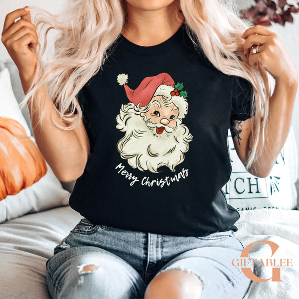 A woman wearing a black t-shirt with a Santa Claus graphic and the text "Merry Christmas" printed on it.