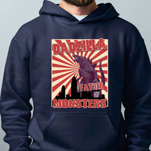A person wearing a navy blue hoodie with a graphic design featuring a large image of a Godzilla-like creature and the text "DADZILLA FATHER OF MONSTERS" printed on it.