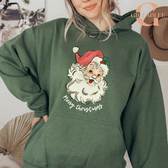 A woman wearing a green hoodie with a graphic of Santa Claus and the text "Merry Christmas" printed on it.