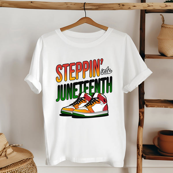 A white t-shirt with a graphic design featuring a pair of colorful sneakers and the text "StepPIN' into JUNETHEN".