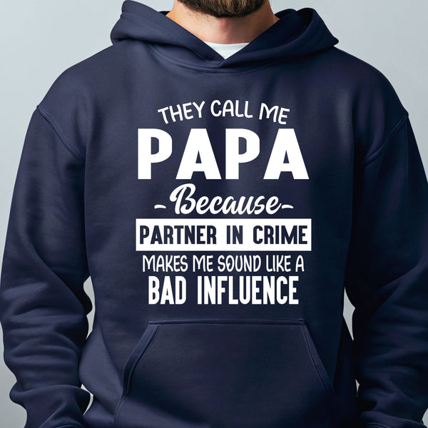 A navy blue hoodie with white text that reads "They call me PAPA because - partner in crime makes me sound like a bad influence".