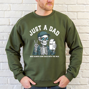 A man wearing a green sweatshirt with a graphic design of a skeleton wearing sunglasses and holding a carton of milk.