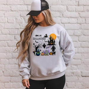 A woman wearing a gray sweatshirt with a Halloween-themed graphic design, including a castle, bats, pumpkins, and other spooky elements.