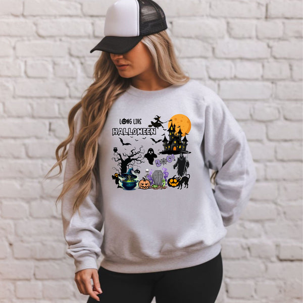 A woman wearing a gray sweatshirt with a Halloween-themed graphic design, including a castle, bats, pumpkins, and other spooky elements.