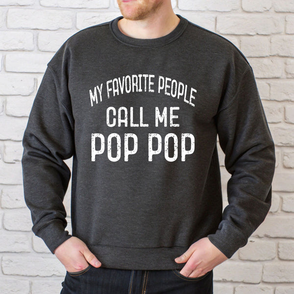 A man wearing a gray sweatshirt with the text "MY FAVORITE PEOPLE CALL ME POP POP" printed on it.