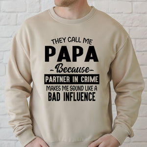 a man wearing a beige sweater with a humorous text printed on it.