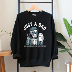 A black sweatshirt with a graphic design depicting a skeleton wearing sunglasses and holding a carton of milk, along with the text "Just a Dad" and "Who always came back with the milk".