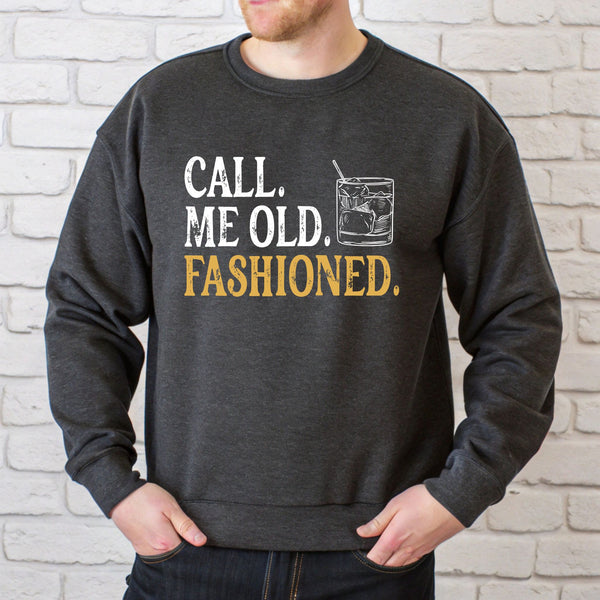 A man wearing a grey sweatshirt with the text "CALL. ME OLD. FASHIONED." printed on it.