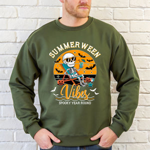 A man wearing a green sweatshirt with a graphic design featuring a skeleton wearing sunglasses and holding a drink, along with the text "Summer Ween Vibes Spooky Year Round".