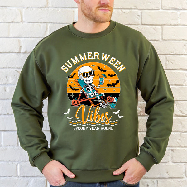 A man wearing a green sweatshirt with a graphic design featuring a skeleton wearing sunglasses and holding a drink, along with the text "Summer Ween Vibes Spooky Year Round".