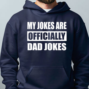 A navy blue hoodie with the text "MY JOKES ARE OFFICIALLY DAD JOKES" printed on it.